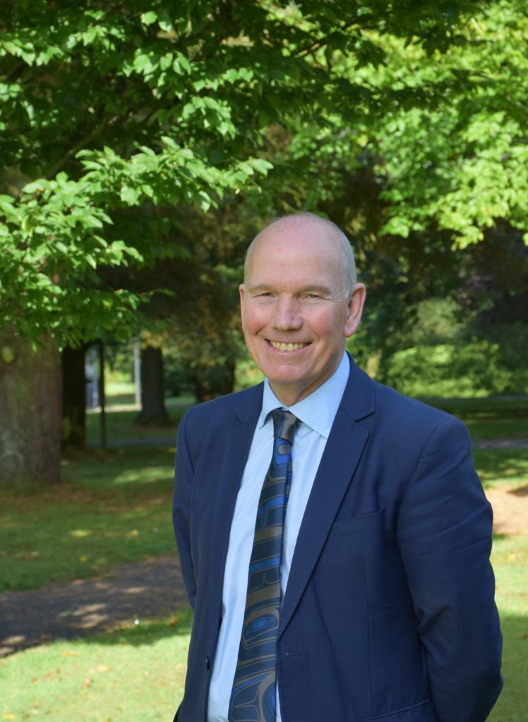 Professor David Clark standing with trees